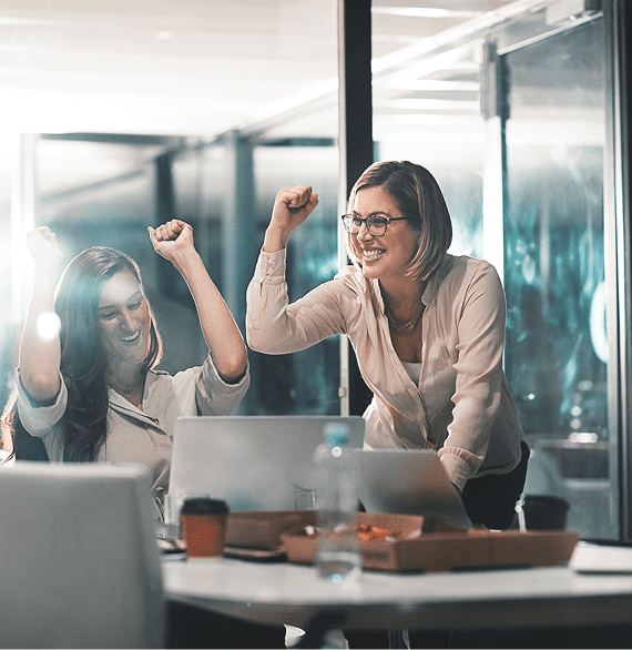 Two women celebrating in an office.