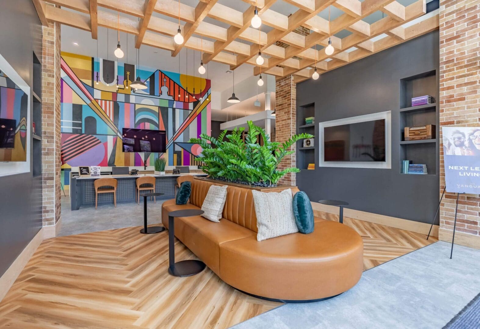 Modern office lounge with colorful mural and stylish furniture.