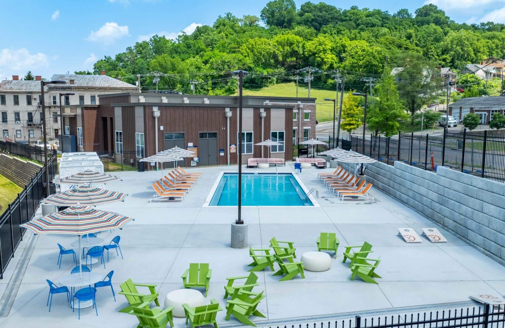A modern outdoor pool area with lounge chairs and greenery.