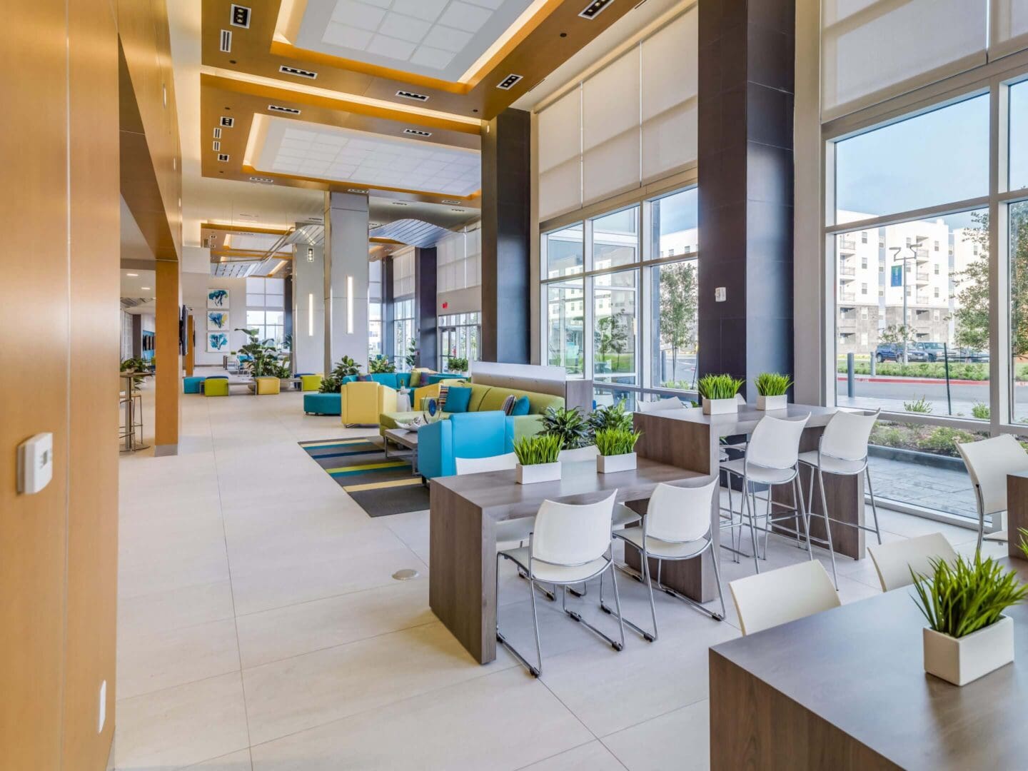 Modern cafe seating with high chairs and colorful couches.