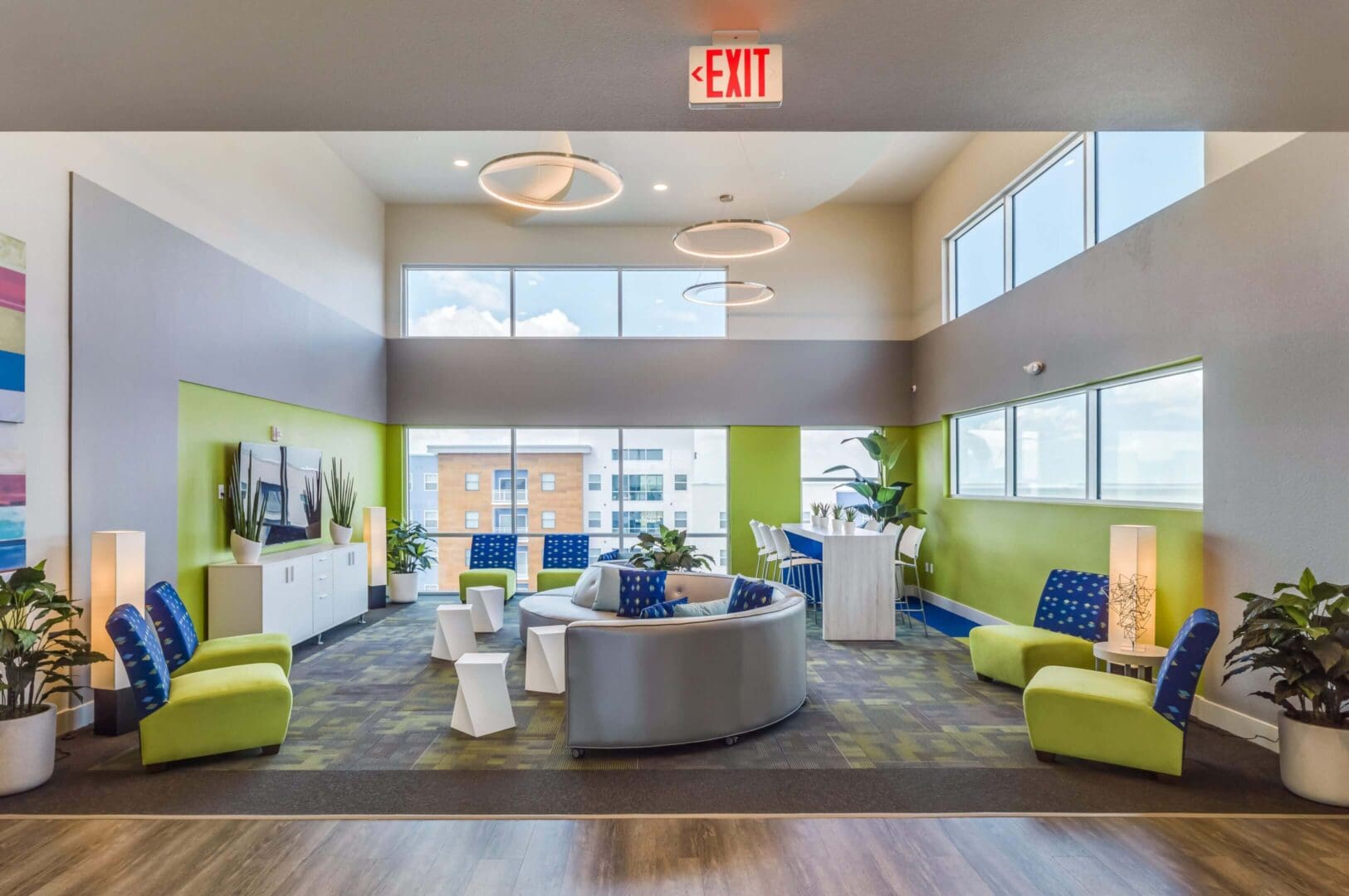 Modern lounge with colorful seating and large windows.