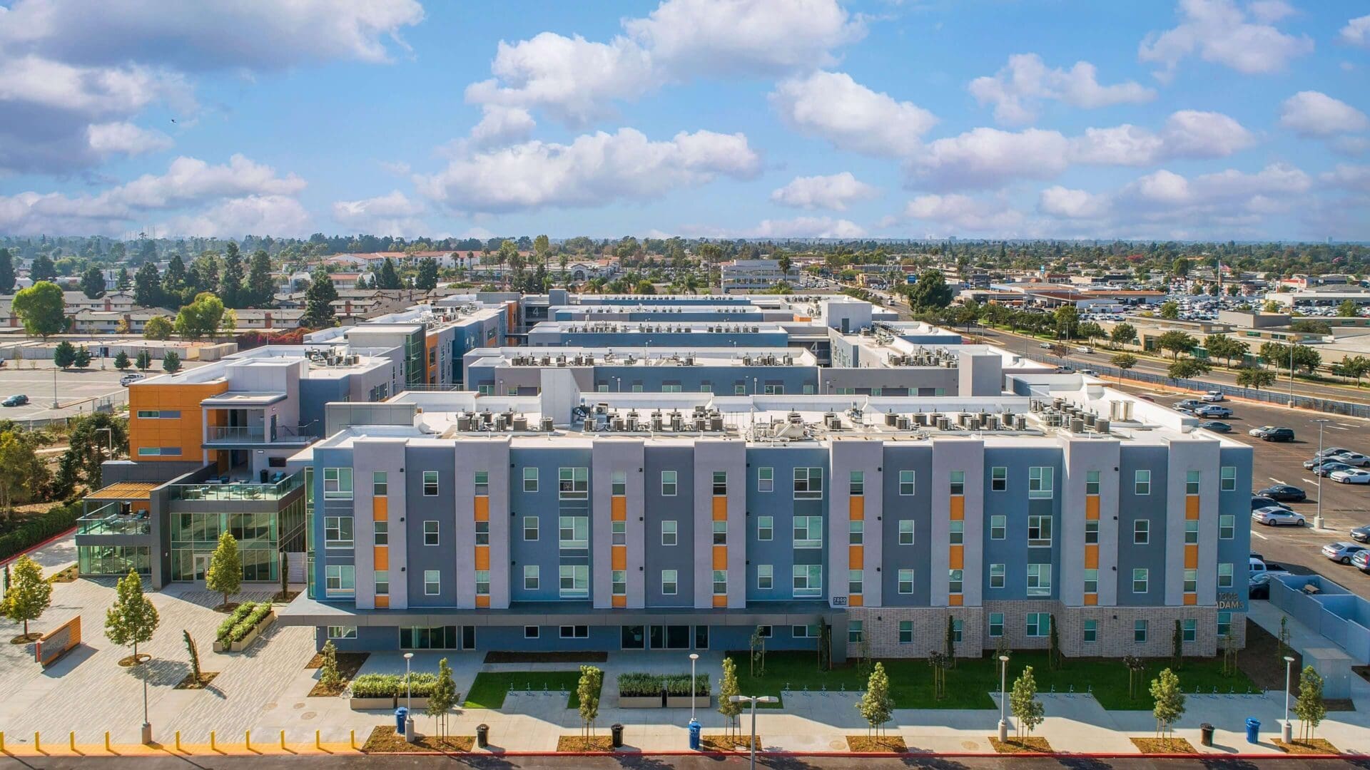 A modern apartment complex under a partly cloudy sky.