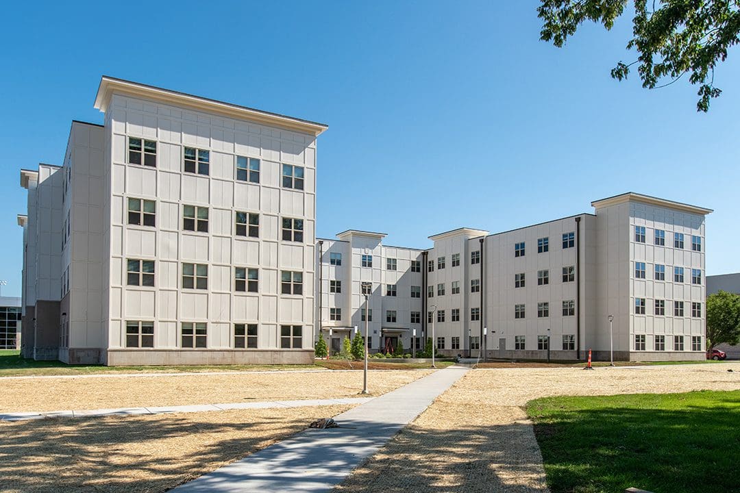 Modern residential buildings with clear blue sky and open courtyard.
