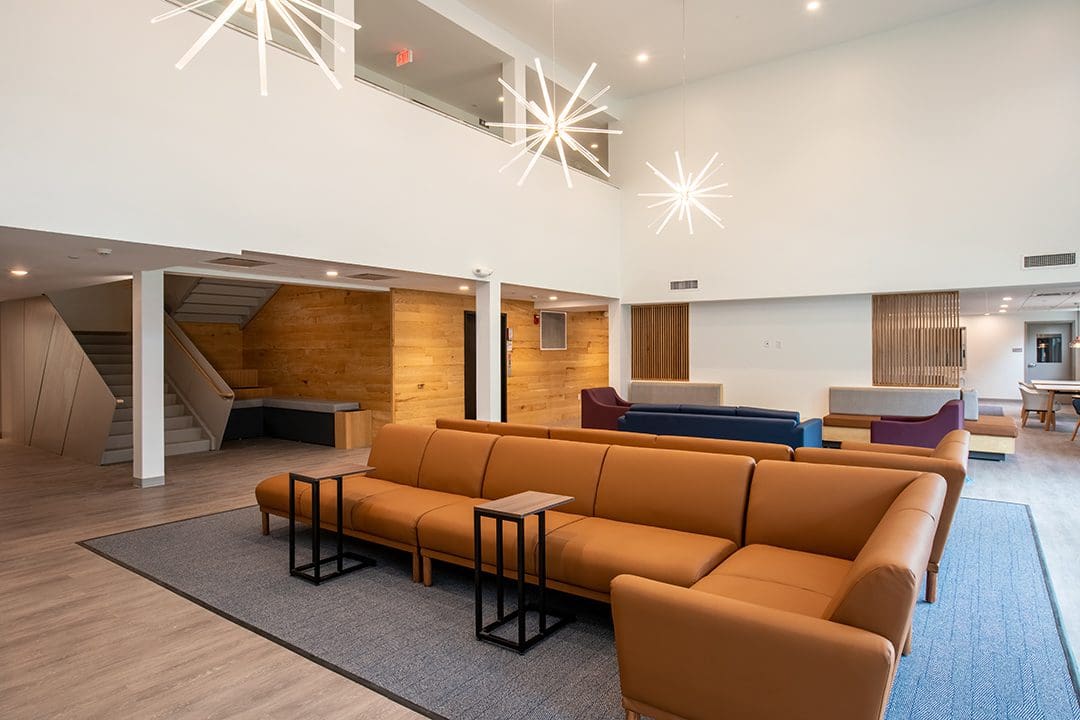 Modern lounge area with brown sofas and unique lighting fixtures.